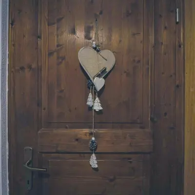 a heart shaped object hanging on a wooden wall at Una Civetta sul Lago in Alleghe
