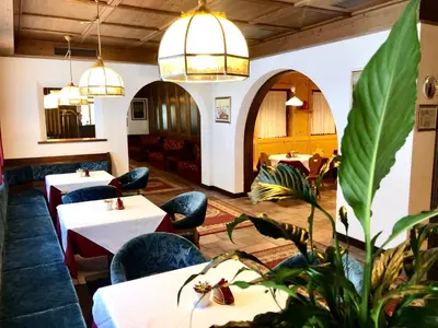a lobby with red couches and chairs in a building at Hotel Molino in Falcade