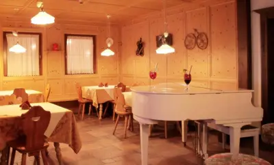 a living room with a couch and chairs and a table at Hotel Molino in Falcade