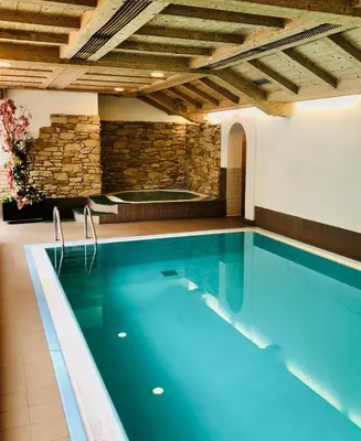 a building with a hot tub in the middle at Hotel Molino in Falcade