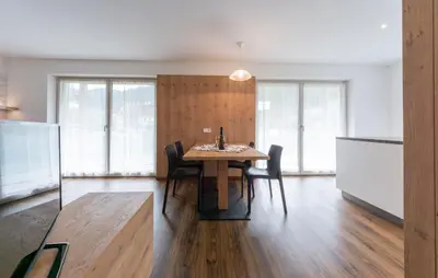 a dining room with a wooden table and chairs at Ciasa Pradac in San Vigilio Di Marebbe