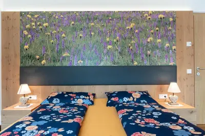 a bedroom with two beds and a painting of flowers at Ciasa Pradac in San Vigilio Di Marebbe