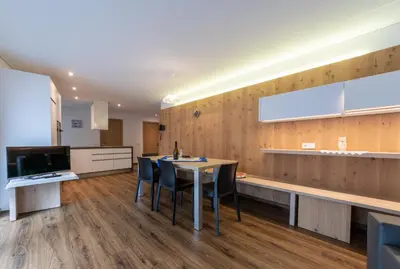 a kitchen and dining room with a table and chairs at Ciasa Pradac in San Vigilio Di Marebbe