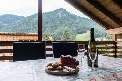 a table with a bottle of wine and a glass at Ciasa Pradac in San Vigilio Di Marebbe