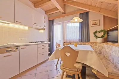 a kitchen with a table with a table cloth on it at Appartamenti Vilin in San Cassiano