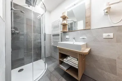a bathroom with a sink and a shower at Appartamenti Vilin in San Cassiano