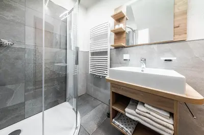 a bathroom with a sink and a shower at Appartamenti Vilin in San Cassiano