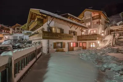 a house in the snow at night at Appartamenti Vilin in San Cassiano