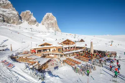 a ski lodge in the snow in front of a mountain at Rifugio Salei in Canazei