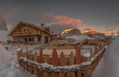 a log cabin in the snow with a fence at Rifugio Salei in Canazei