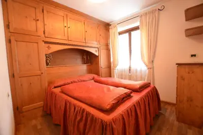 a bedroom with a bed and a window at Lungoboite 14 - Cortina in Cortina dʼAmpezzo