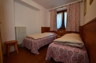 a bedroom with two beds and a window at Lungoboite 14 - Cortina in Cortina dʼAmpezzo
