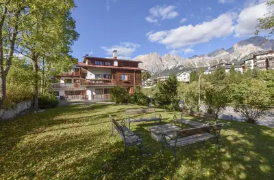 a group of benches in a yard with a building at Lungoboite 14 - Cortina in Cortina dʼAmpezzo