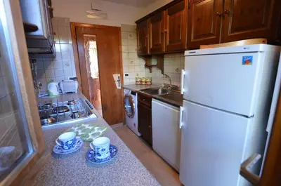 a kitchen with a white refrigerator and a sink at Lungoboite 14 - Cortina in Cortina dʼAmpezzo