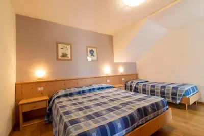 a bedroom with two beds in a attic at Appartamenti Le Plejadi in Cavalese