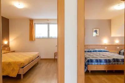 a bedroom with two beds and a window at Appartamenti Le Plejadi in Cavalese