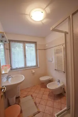 a bathroom with two sinks and a toilet at Appartamenti Le Plejadi in Cavalese