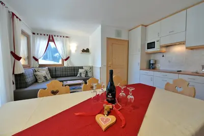 a kitchen with a table with a bottle of wine on it at Apartment Albert in Santa Cristina in Val Gardena