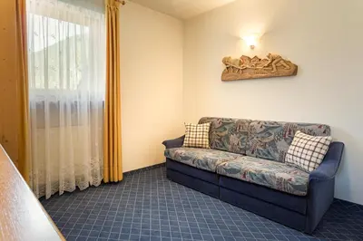 a living room with a couch and a window at Residence Telemark in Santa Cristina in Val Gardena