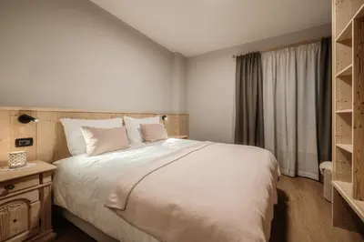 a bedroom with a large white bed and a window at Residence Telemark in Santa Cristina in Val Gardena