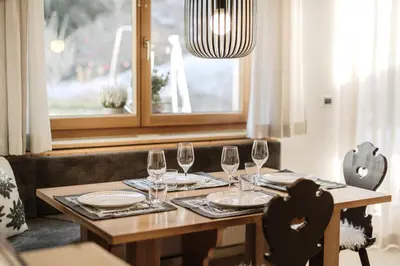 a wooden table with glasses and plates on it at Residence Telemark in Santa Cristina in Val Gardena