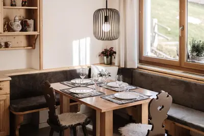 a dining room table with two chairs and a pendant light at Residence Telemark in Santa Cristina in Val Gardena