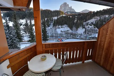 a balcony with a table and chairs and a mountain view at Albert - Bon Di in Santa Cristina in Val Gardena