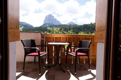 a balcony with chairs and a table with a view at Albert - Bon Di in Santa Cristina in Val Gardena