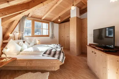 a bedroom with a large bed and a tv at Albert - Bon Di in Santa Cristina in Val Gardena