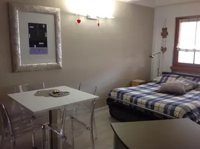 a room with two beds and a table and a mirror at Home White in Laives