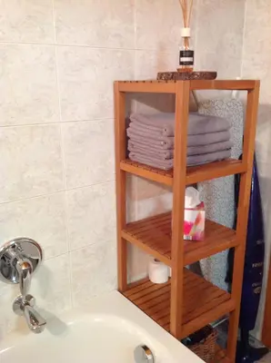 a wooden towel rack next to a sink in a bathroom at Home White in Laives