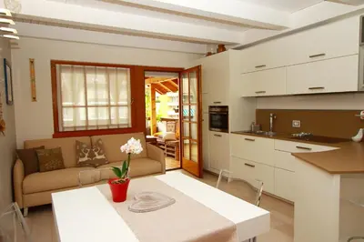 a kitchen and living room with a couch and a table at Home White in Laives