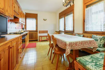 a kitchen with a table and a table and chairs at Villa Ca Perosego - Stayincortina in Cortina dʼAmpezzo