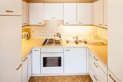 a kitchen with white cabinets and a sink at Haus Klavenz in Caldaro
