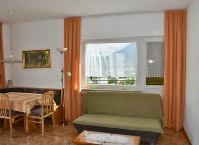 a living room with a couch and a table and a window at Haus Klavenz in Caldaro