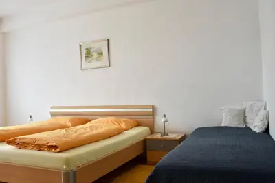 a bedroom with two beds and a night stand with a lamp at Haus Klavenz in Caldaro