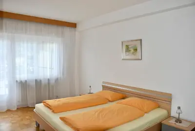 a bedroom with a bed with orange pillows on it at Haus Klavenz in Caldaro