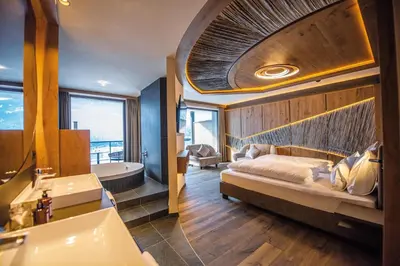 a bathroom with a bed and a tub and a sink at Leitgam Adults Only Hotel in Chienes