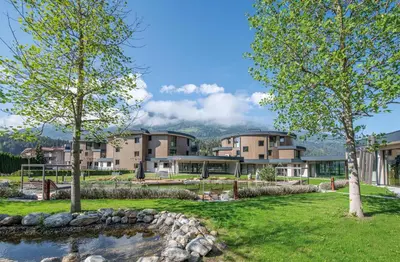 a view of a building with trees and a pond at Leitgam Adults Only Hotel in Chienes