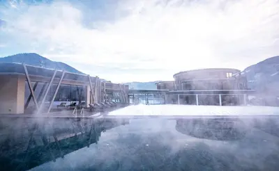 a building next to a body of water with snow at Leitgam Adults Only Hotel in Chienes