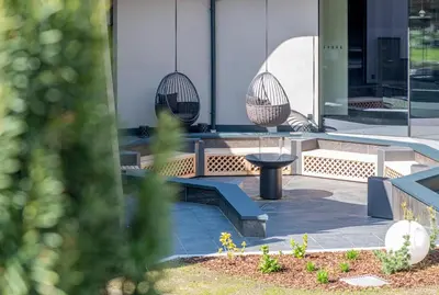 a patio with benches and a table in front of a building at Leitgam Adults Only Hotel in Chienes