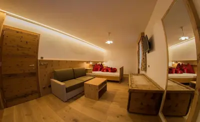 a bedroom with a bed and a group of chairs at Apartments Edera in Selva di Val Gardena