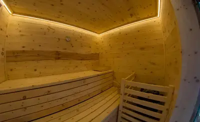 a large wooden house on a hill with a yard at Apartments Edera in Selva di Val Gardena