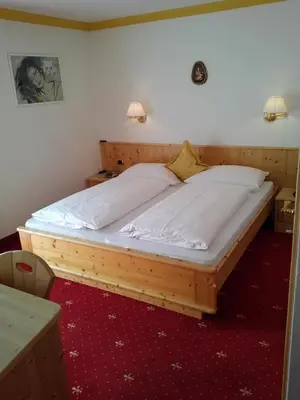 a large wooden bed in a room at Garni Waltoy in Selva di Val Gardena