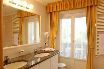 a bathroom with two sinks and a large mirror at Garni Waltoy in Selva di Val Gardena