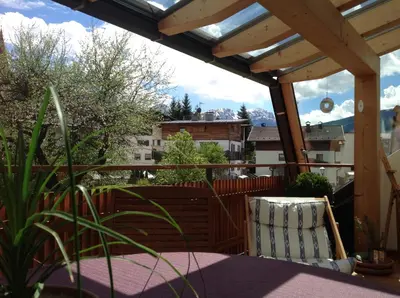 a patio with a pergola and a table and chairs at Bio.top.Appartement in Rasun di Sopra