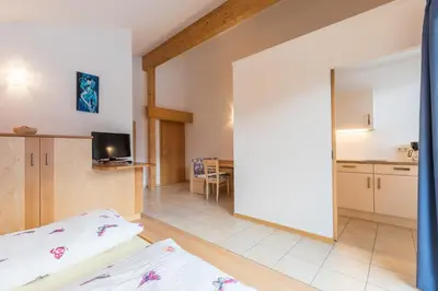 a living room with a bed and a kitchen at Appartements Haus Pichler in Eggen