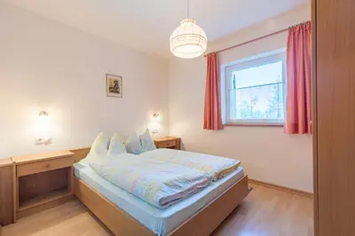 a bedroom with a bed and a window at Appartements Haus Pichler in Eggen