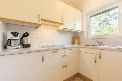 a kitchen with white cabinets and a window at Appartements Haus Pichler in Eggen