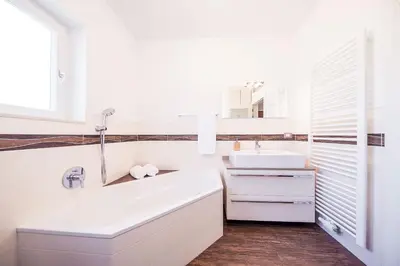 a white bathroom with a tub and a sink at Josefshof in Caldaro